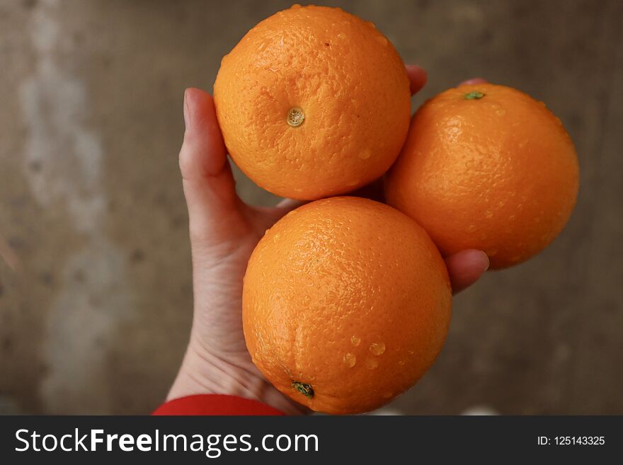 Ripe orange citrus fruit held in hand on a natural background. Vitamin C. Ripe orange citrus fruit held in hand on a natural background. Vitamin C