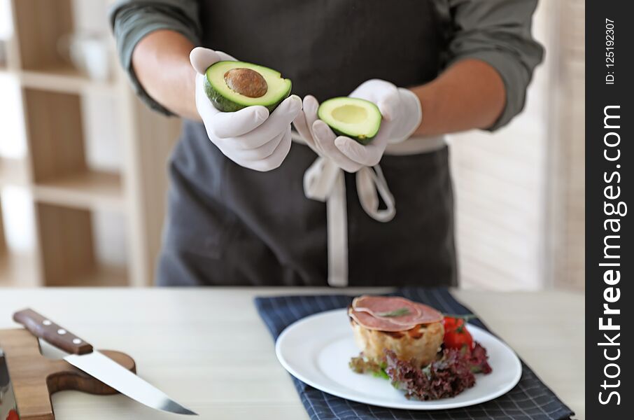 Professional chef preparing dish on table in kitchen, closeup