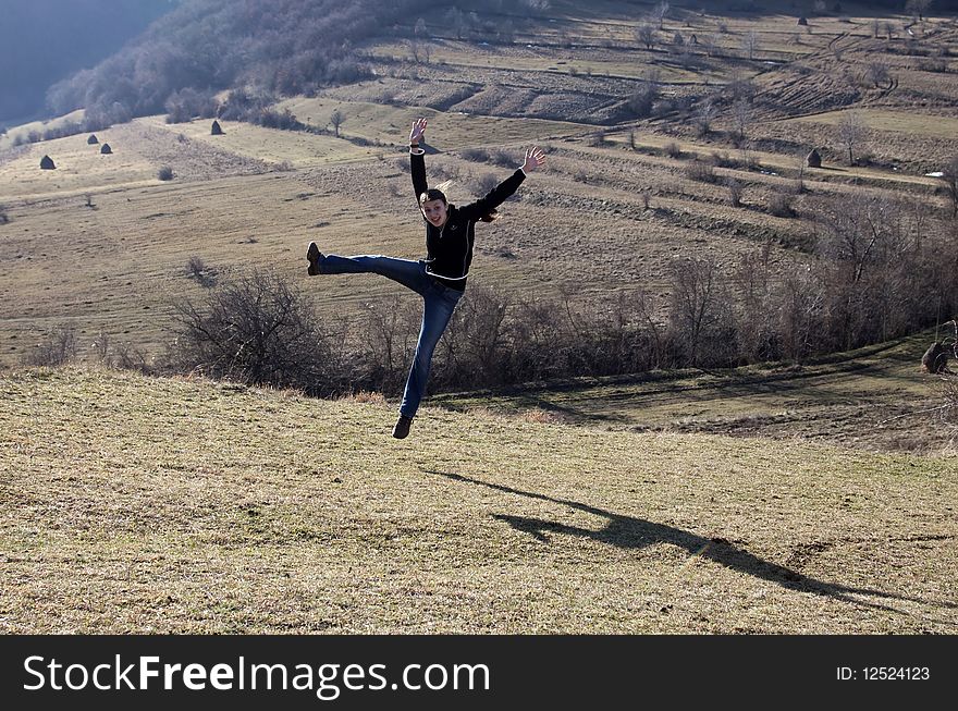 Happy young woman jumping in field