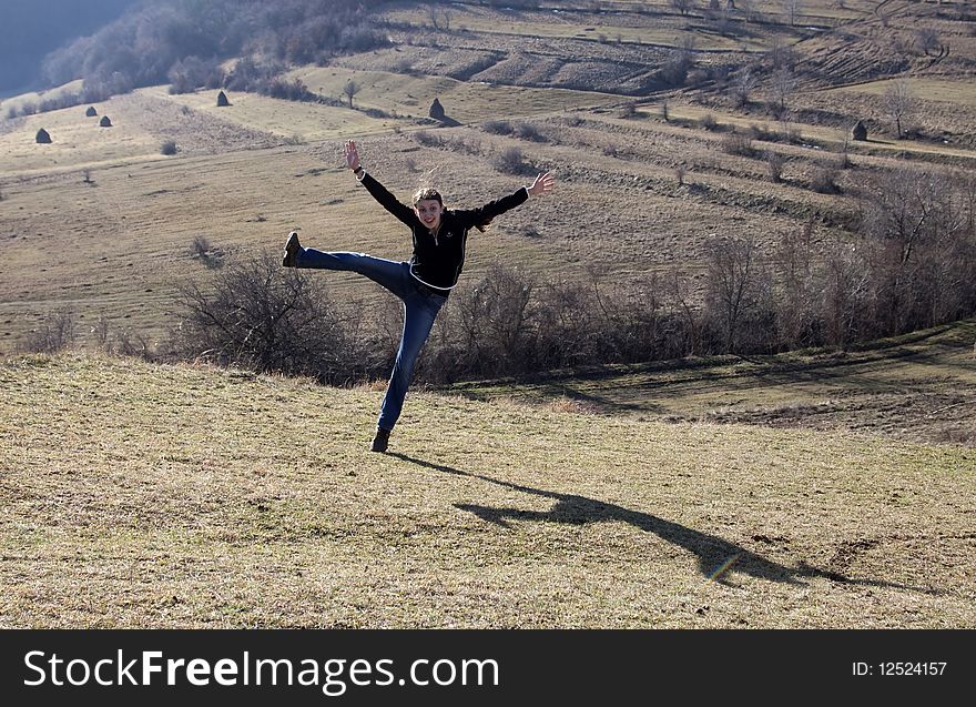 Happy young woman jumping in field