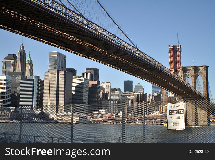 Lower angle view of Brooklyn bridge over East river with Manhattan skyline in background, New York city, U.S.A.
