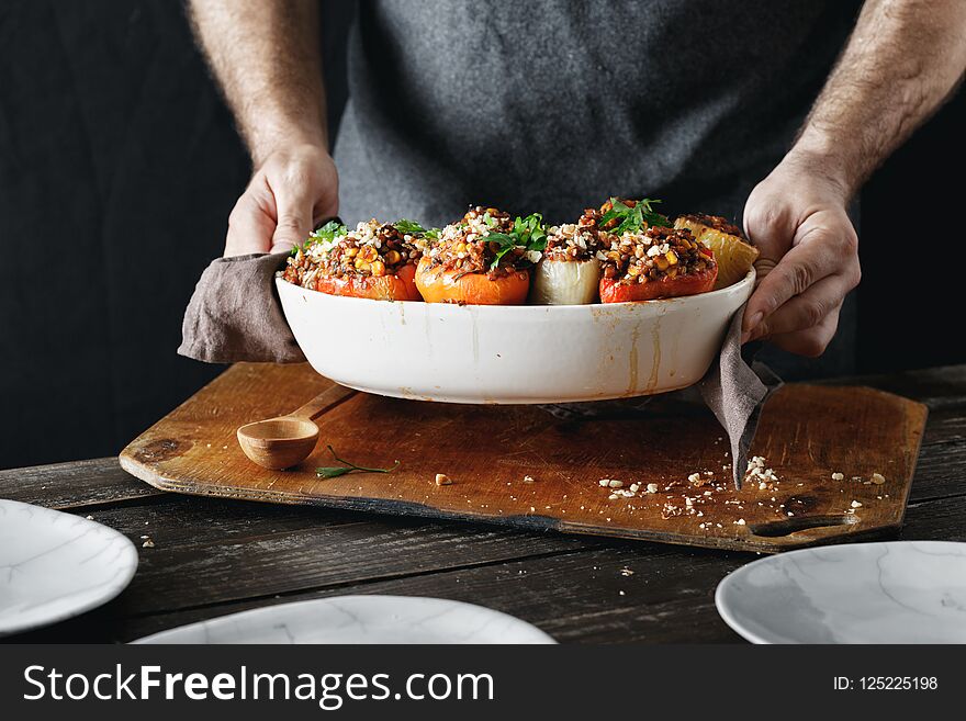 Male hands holding cooked stuffed peppers Healthy vegetarian foo