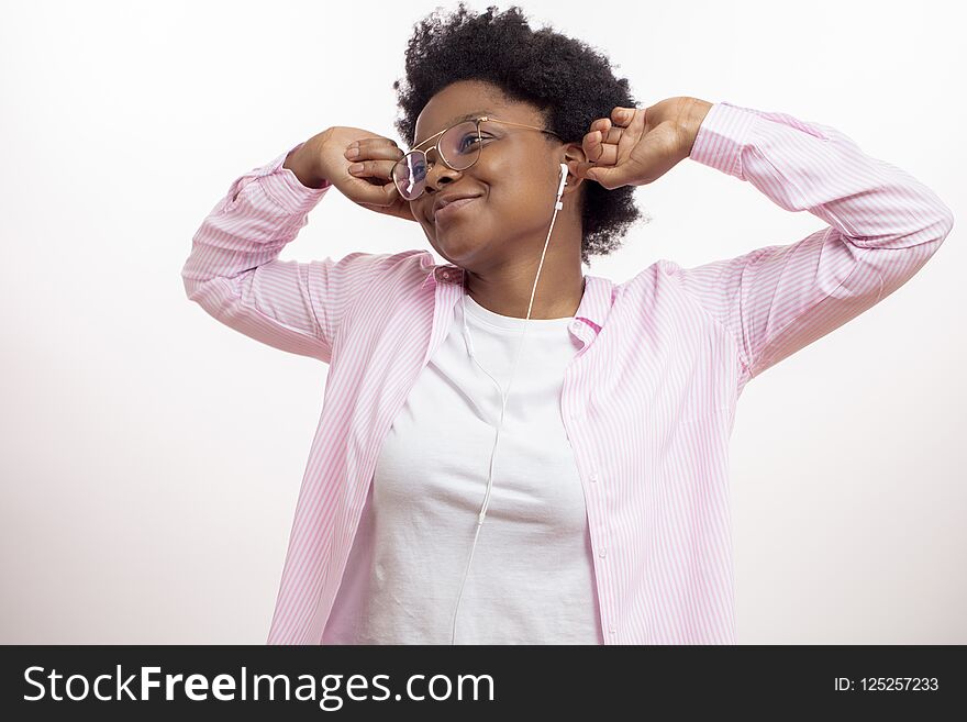 Sleepy cheerful black woman waking up with music