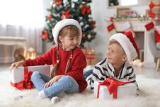 Cute Little Children In Santa Hats With Christmas Gift Stock Photos