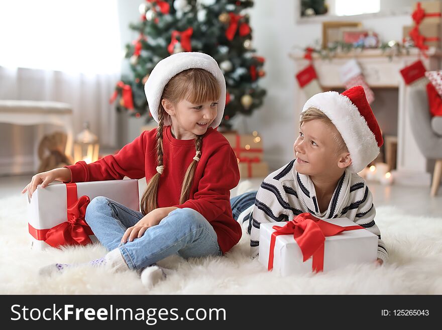 Cute little children in Santa hats with Christmas gift