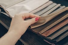 Free The Girl Is Viewing Samples Of Fabric For Furniture In Home Or Commercial Building. Large Color Catalog Of Fabric. Design. Stock Photo - 125284370