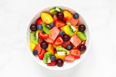 Bowl Of Healthy Fresh Fruit Salad On White Marble Background. Healthy Food Royalty Free Stock Photos