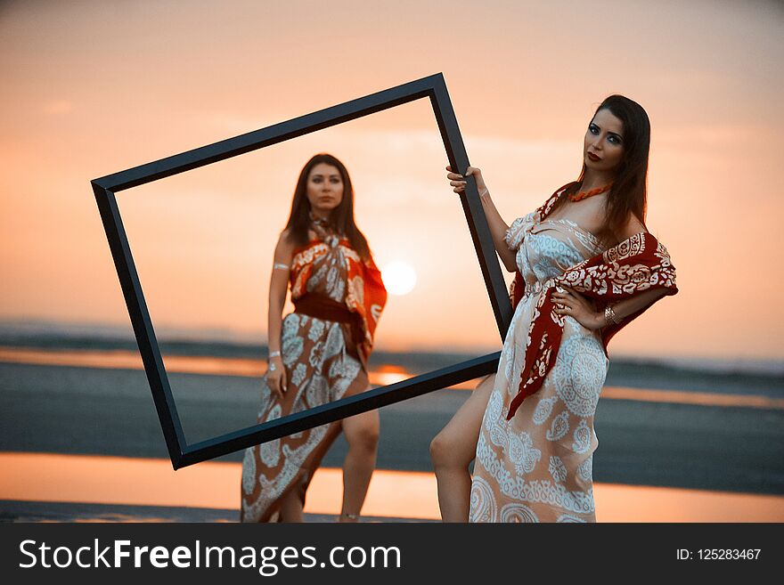 Portrait of a Two Young women holding an empty frame