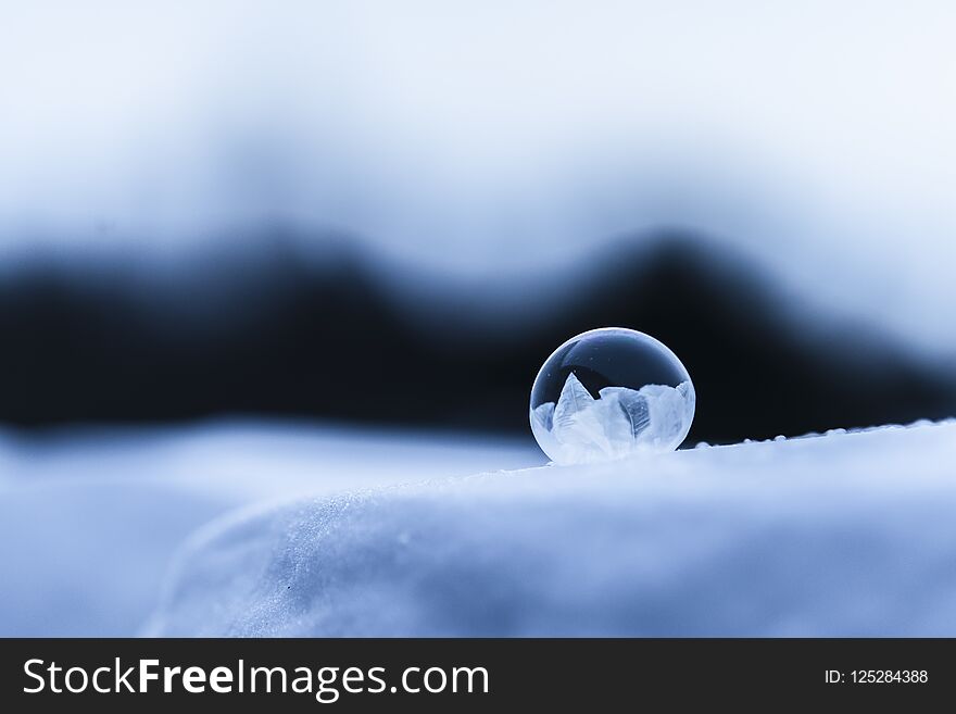 Frozen round soap bubble on snow
