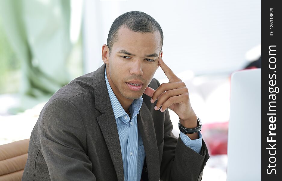 Portrait of pensive businessman sitting behind a Desk.photo with copy space