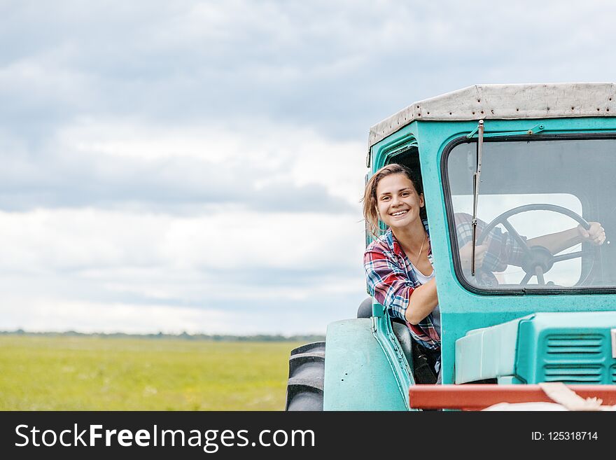 Young Beautiful Girl Working On A Tractor In The Field, Unusual