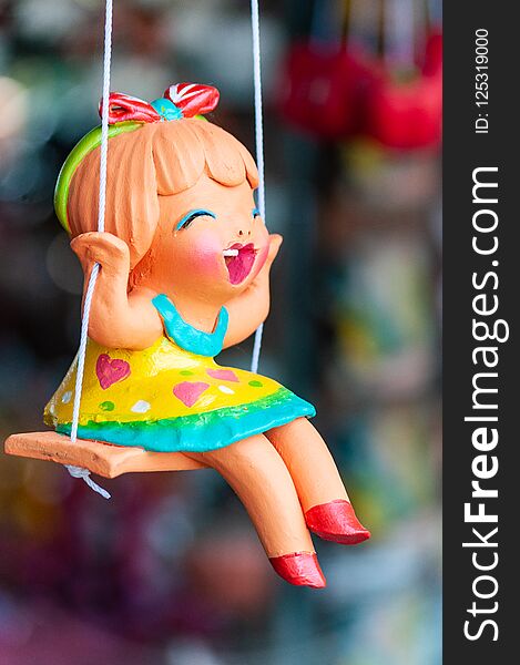 A ceramic doll on a swing