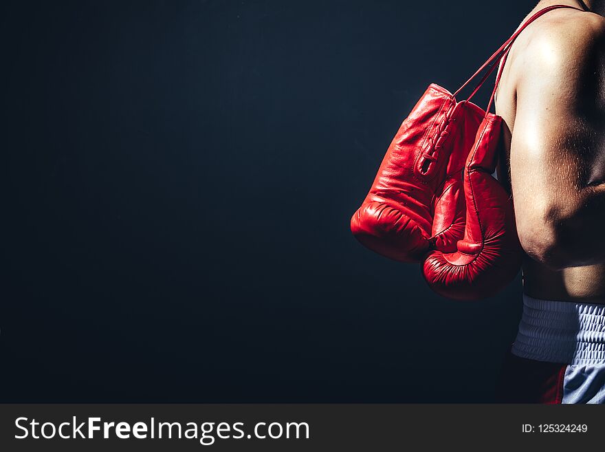 Pair of red gloves on the fighter`s back. Boxing equipment. Close-up.