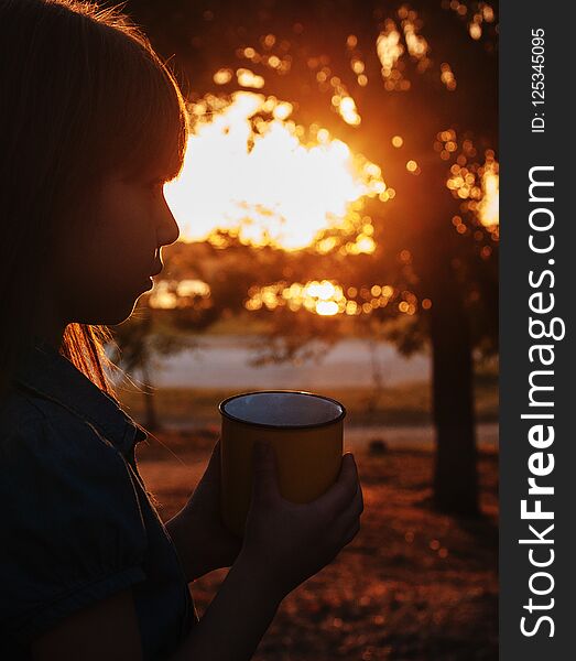 Cute little girl with a cup in autumn park. Cute little girl with a cup in autumn park.