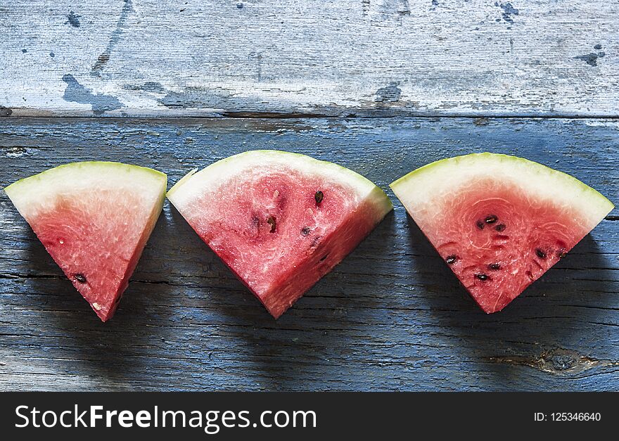 slices of watermelon on rustic wooden background, top view. slices of watermelon on rustic wooden background, top view