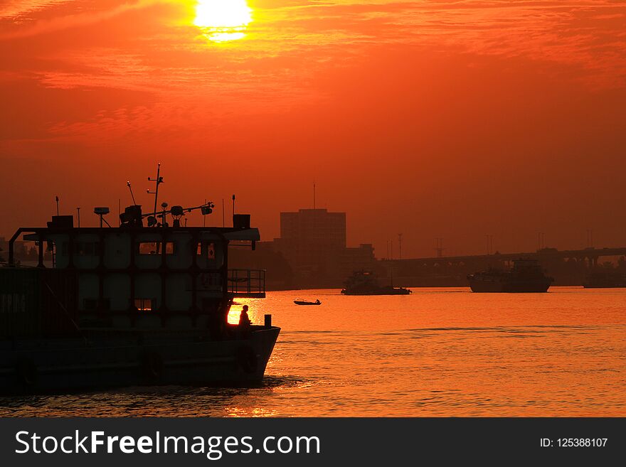 In the winter sun, the cargo-carrying ships are sailing slowly in the river. In the winter sun, the cargo-carrying ships are sailing slowly in the river