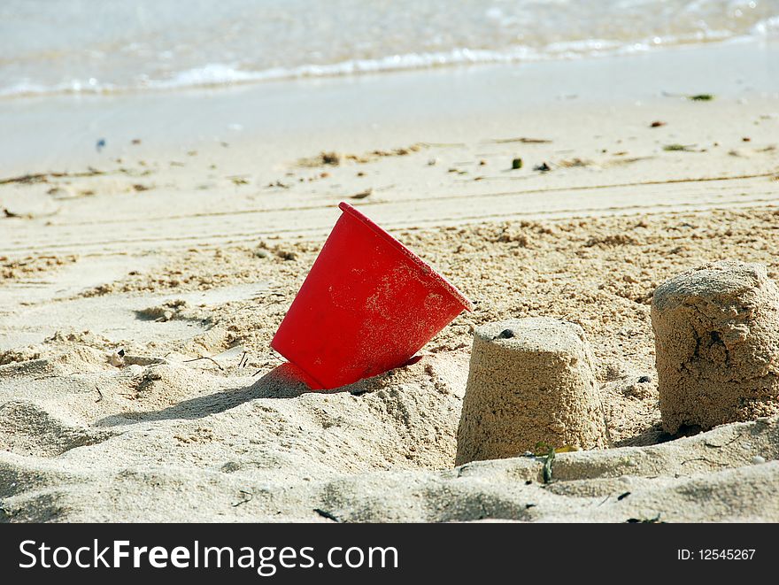 Red pail in sand near ocean. Red pail in sand near ocean