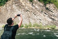 Yong Traveler Taking Photo Near Mountain River Stock Photo