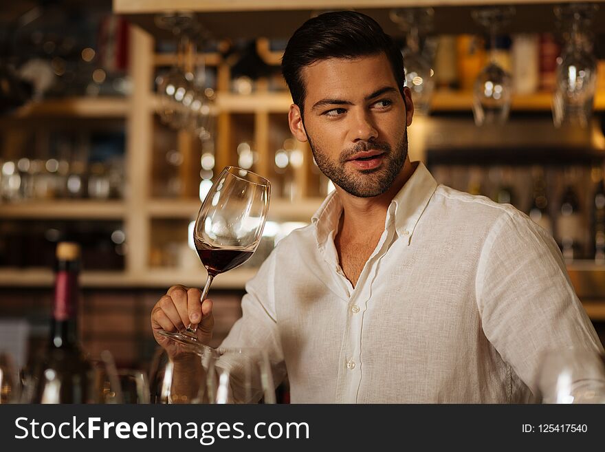 Attractive nice man enjoying to drink wine