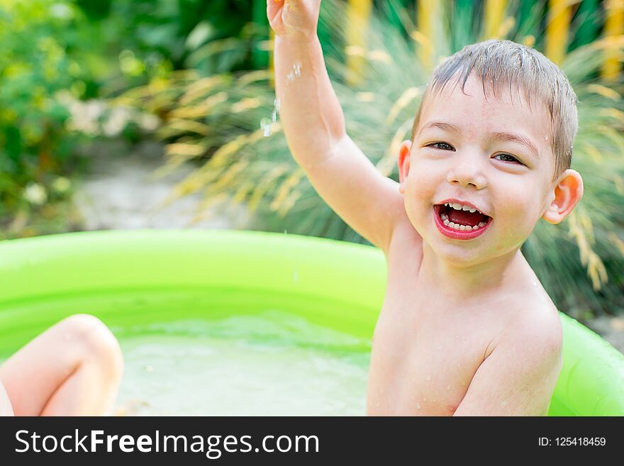 Children playing in inflatable baby pool. Kids swim and splash