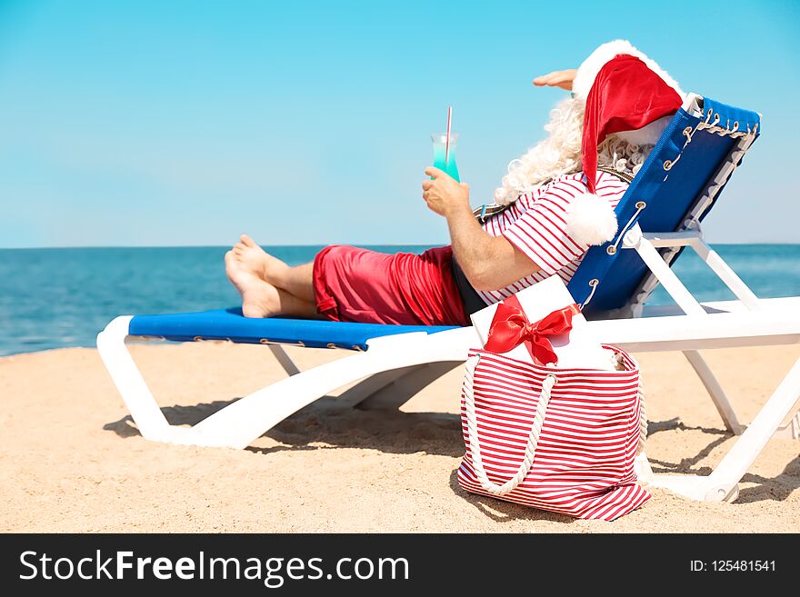 Authentic Santa Claus with cocktail resting on lounge chair