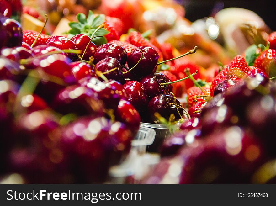 Cherries and strawberries fruit in a market in barcelona spain