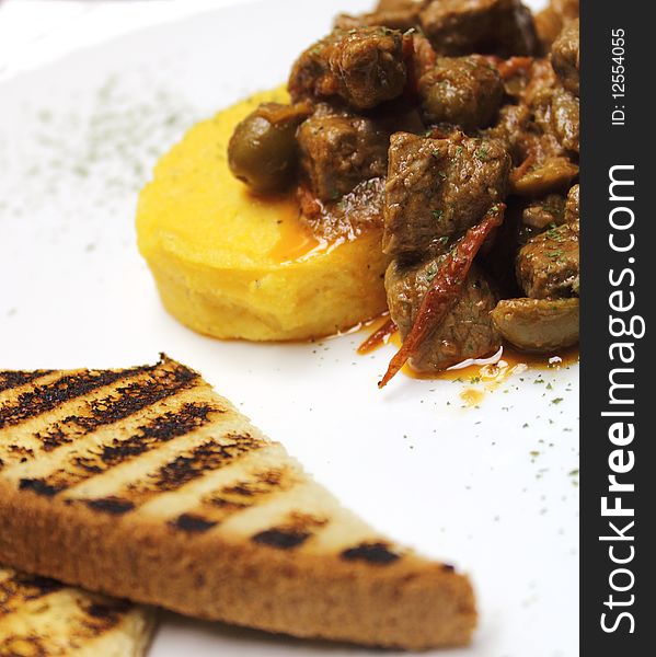 Plate of meat, polenta and grilled bred. Plate of meat, polenta and grilled bred