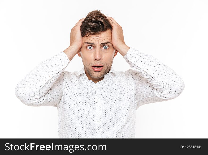 Portrait of irritated disappointed man 20s grabbing his head and