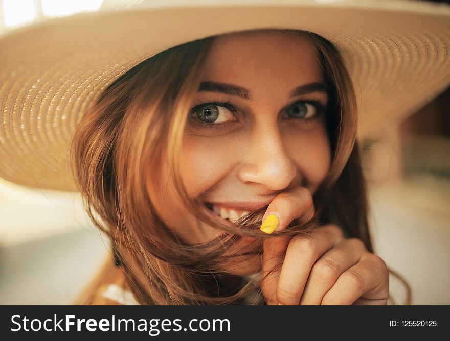 Portrait of young smiling woman in hat. Closeup.