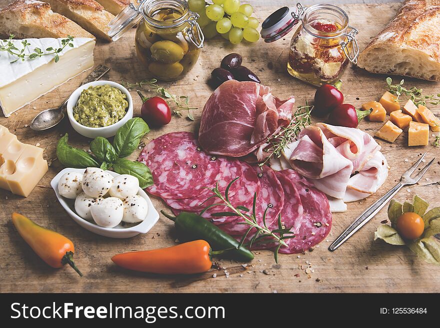 Wooden Board With Prosciutto, Salami,bacon And Cheese Mozzarella Brie,olives