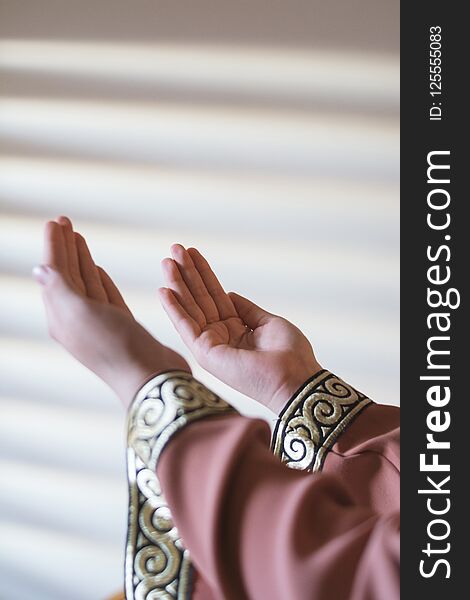 Hands of muslim people praying with mosque interior background.