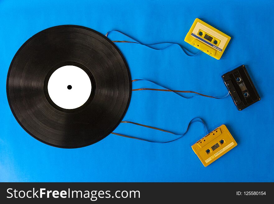 Top view old vinyl records and tape cassette on blue background