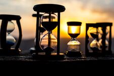 Hourglass Passing Of Time Lapse Clouds. An Hourglass In Front Of A Bright Blue Sky With Puffy White Clouds Passing. Time Concept. Stock Images Hourglass Passing Of Time Lapse Clouds. An Hourglass In Front Of A Bright Blue Sky With Puffy White Clouds Passing. Time Concept. Stock Images