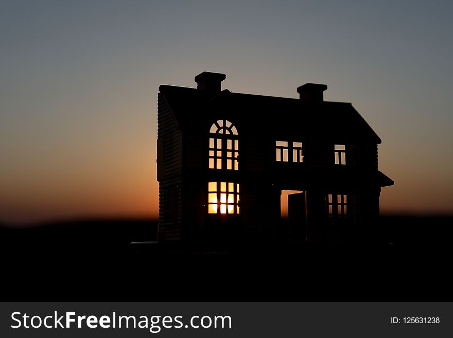 decorative small wooden house on the sunset background. Selective focus. decorative small wooden house on the sunset background. Selective focus
