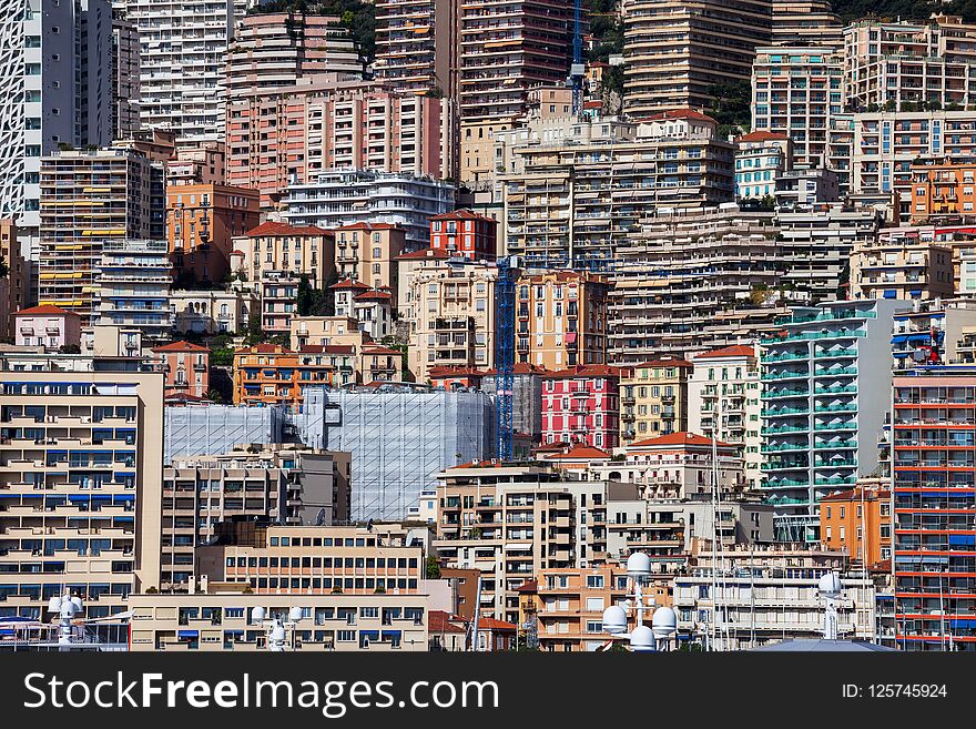 Principality of Monaco cityscape, densely populated urban background on mountain slope with houses, apartment buildings, towers, block of flats