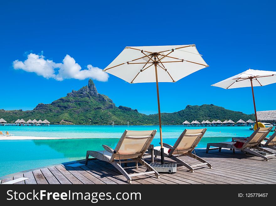 White cloud, blue sky, white umbrella and turquoise water in Bora Bora. White cloud, blue sky, white umbrella and turquoise water in Bora Bora.