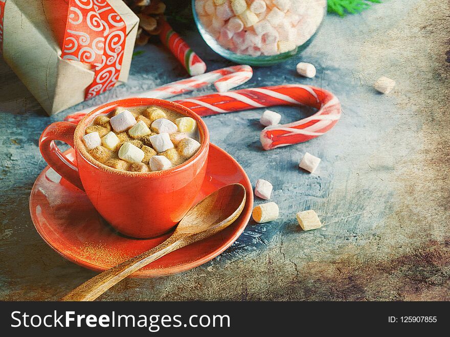 Red Cup of Homemade christmas hot chocolate,for Christmas and winter holidays a fir tree branch, candy canes and ginger biscuits on a wooden background. Holiday Concept, copy space