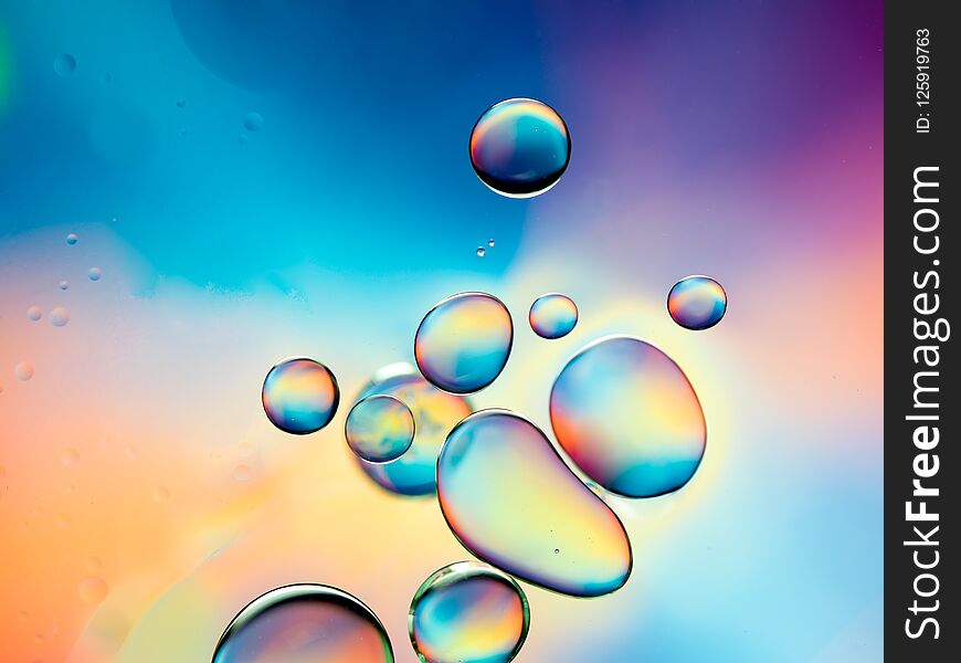 Macro of oil drops on water surface with vibrant colors in background. Macro of oil drops on water surface with vibrant colors in background