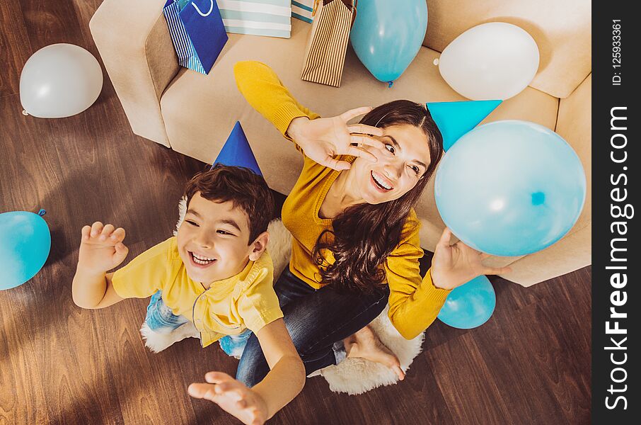 Fun together. Merry positive women and boy laughing while playing with balloons. Fun together. Merry positive women and boy laughing while playing with balloons