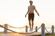 Portrait Of Muscular Young Man Exercising With Jumping Rope Royalty Free Stock Photography