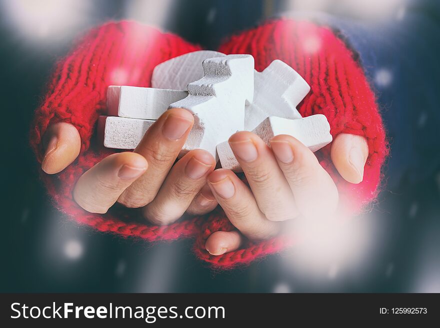 Christmas Background - female hands in red gloves hold a New Year`s toys. Christmas Background - female hands in red gloves hold a New Year`s toys