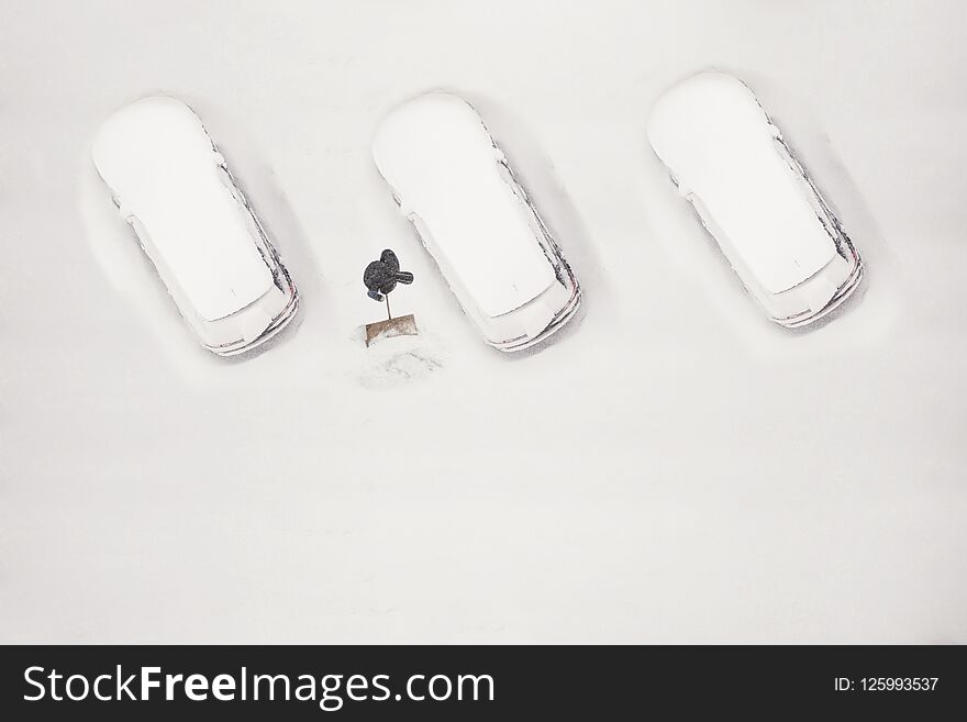 The owner of the car cleans the snow-covered parking space during the snow season. Winter time.