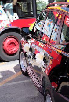 Colourful Bus Passing Black Wedding Car Stock Photo