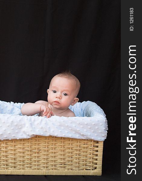 Baby boy sitting in basket. Baby boy sitting in basket