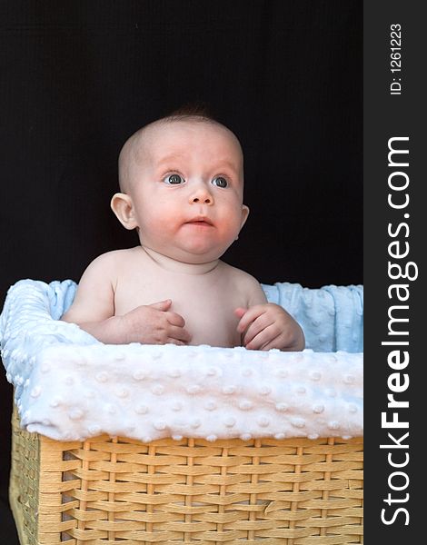 Baby boy sitting in basket. Baby boy sitting in basket