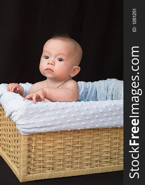 Baby boy sitting in basket. Baby boy sitting in basket