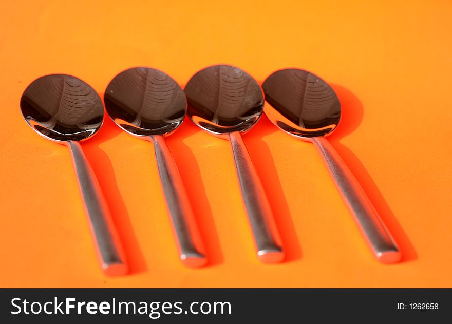 Spoons against an orange background