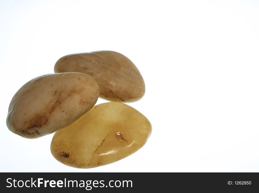 Three smooth stones arranged on a white background
