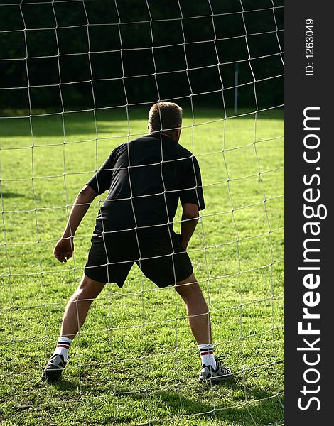 Close up of people at sport, silhouette of a goalkeeper shot from behind. Close up of people at sport, silhouette of a goalkeeper shot from behind