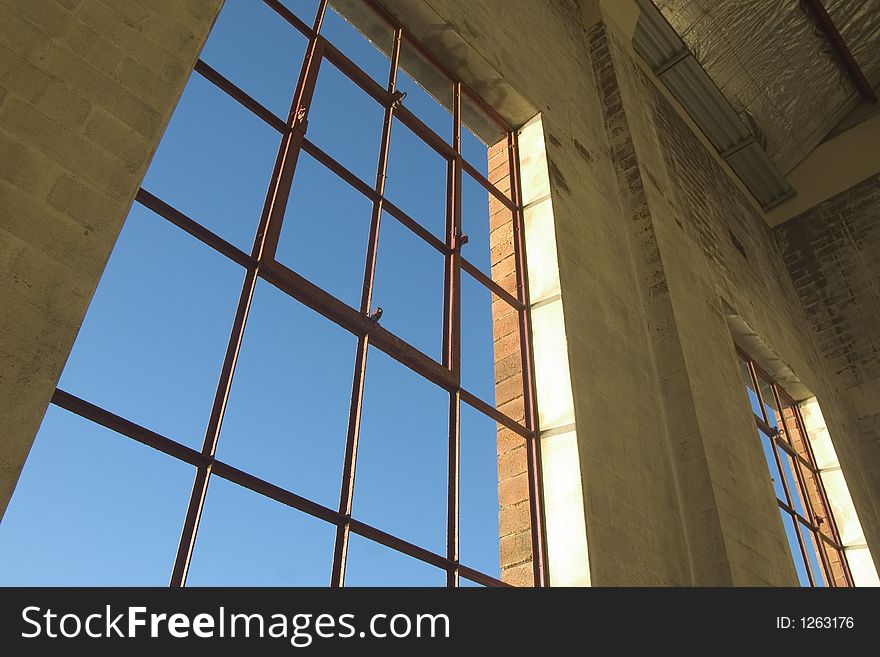 Warehouse window looking out over blue sky